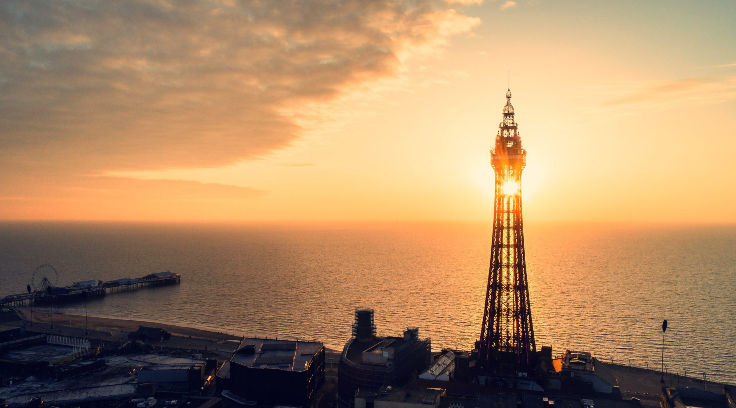 A photograph of blackpool tower at sunset with the sea behind