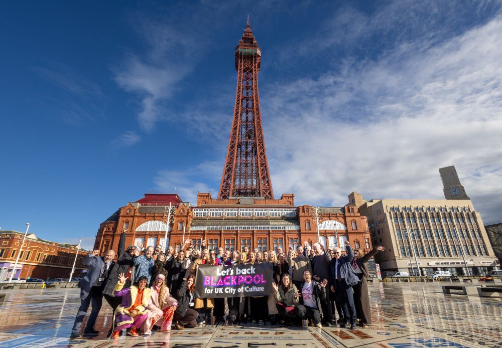 A collection of the people gathered in front of Blackpool Tower on a sunny day.